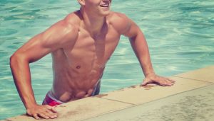 Homem que estava praticando natação saindo da piscina