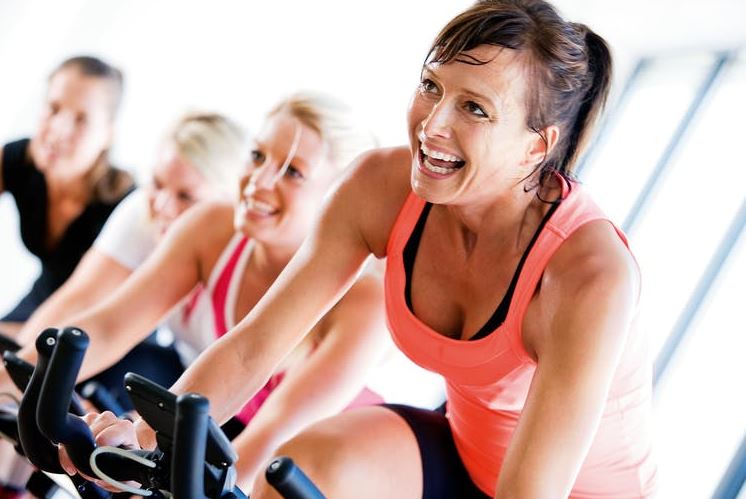 Mulheres fazendo spinning na academia