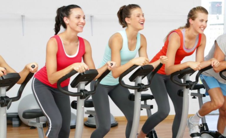 Mulheres praticando spinning na academia