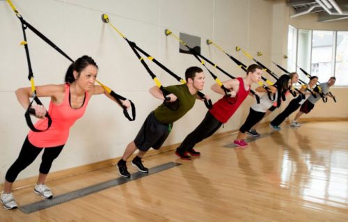 Alunos fazendo treino de musculação no TRX
