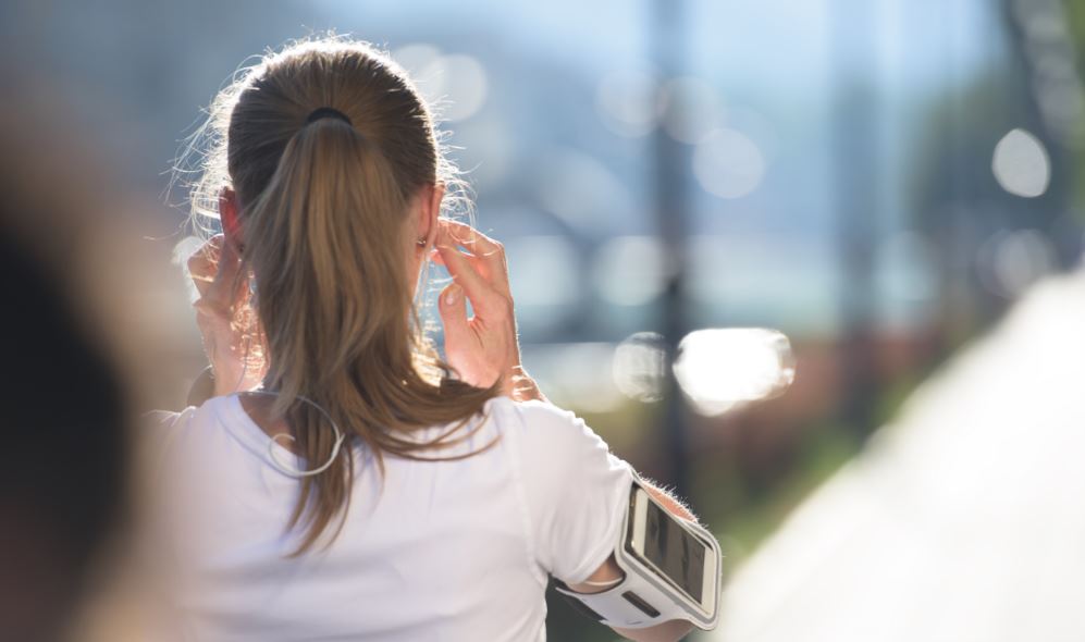 Menina indo correr arrumando os fones de ouvido