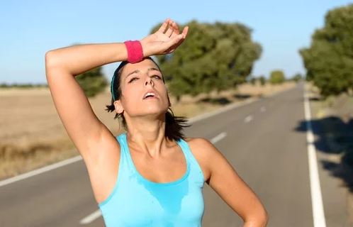 Mulher exaurida fazendo exercício físico ao ar livre