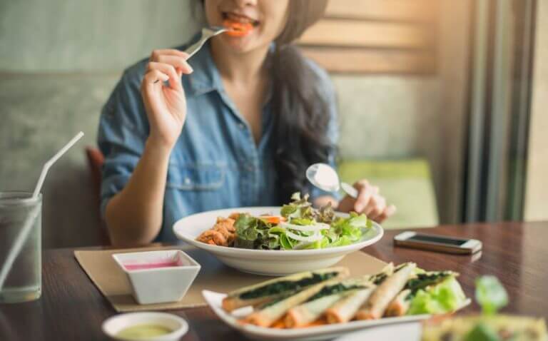 Mulher comendo um prato de salada