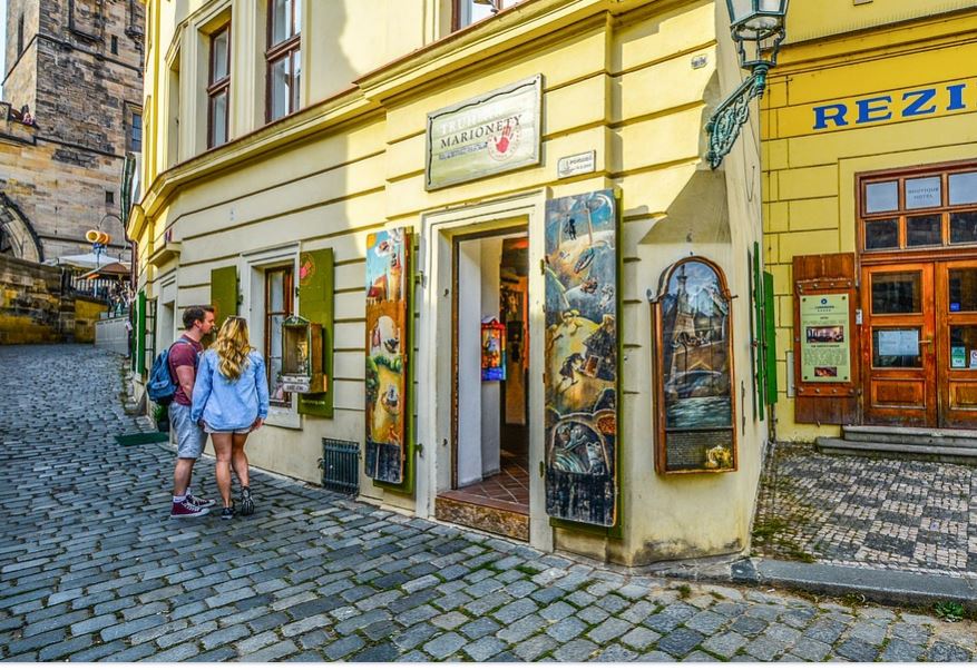 Casal de turistas observando vitrines em uma cidade antiga