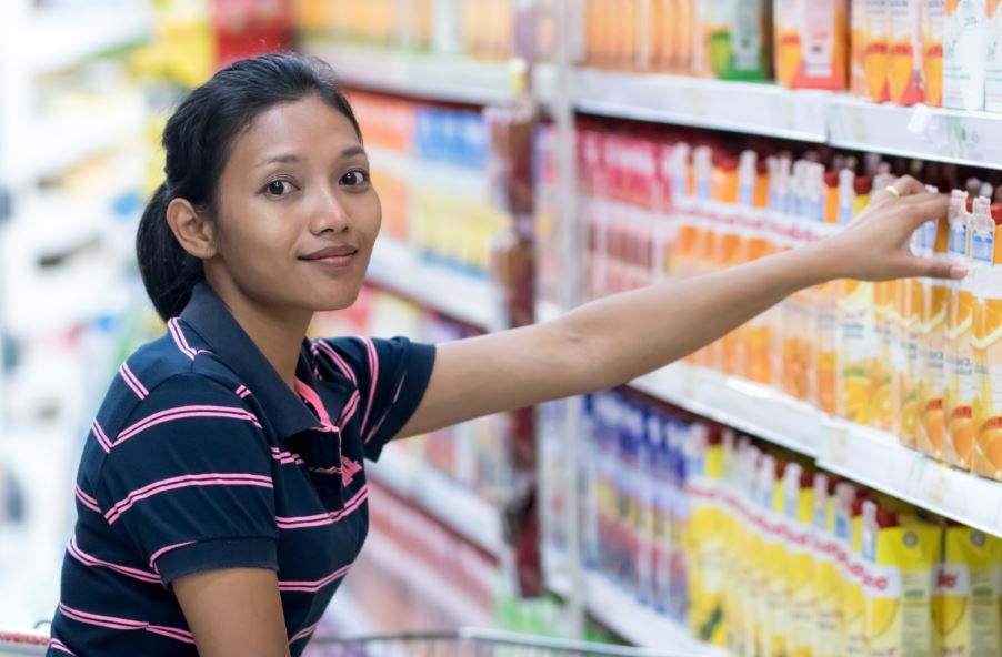 Garota escolhendo suco no mercado