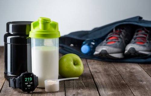 Shake de proteína do lado de uma mochila com um tênis de academia