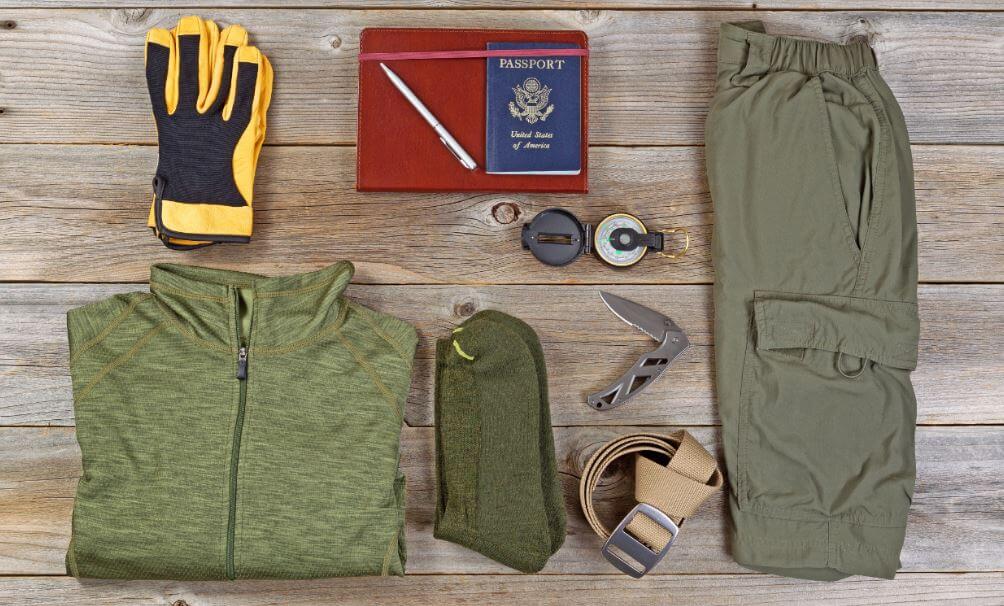Objetos essenciais para trekking como casaco, canivete e documento.
