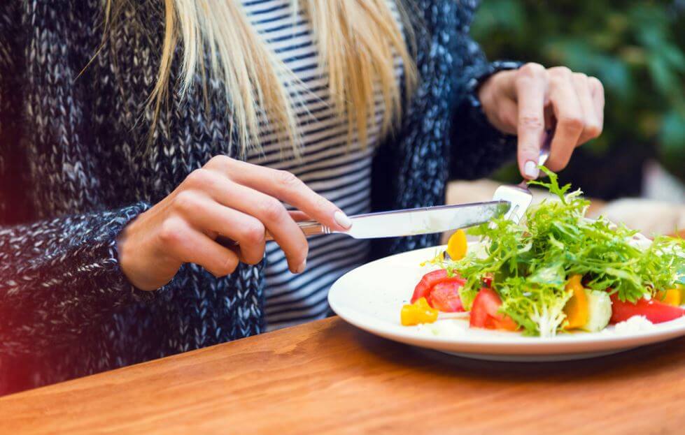 Mulher comendo salada