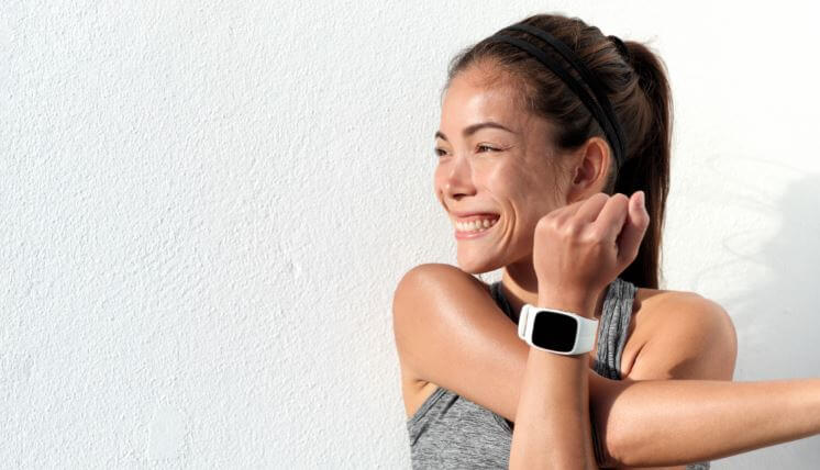 Mulher se alongando com um smartwatch no pulso