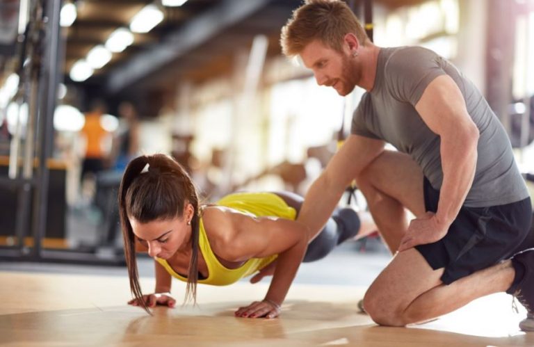 Personal trainer com uma aluna na academia