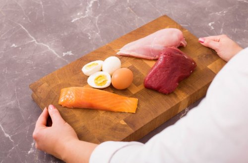 Salmão, frango, ovos e bife em uma tábua de madeira