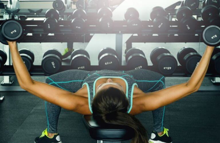 Mulher malhando peito com peso livre