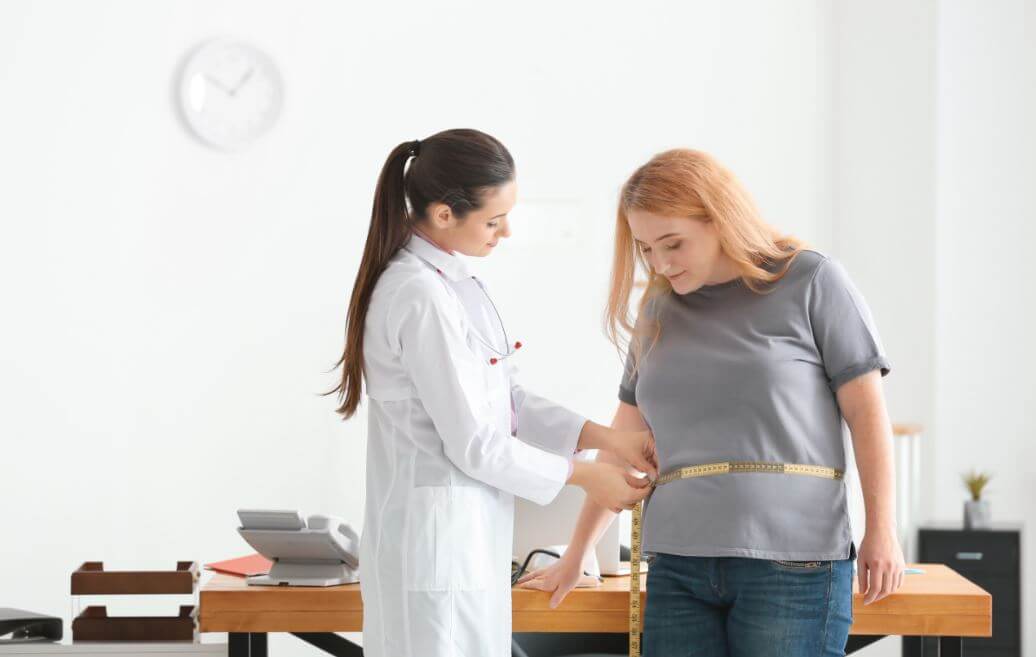 Médica medindo a barriga de uma paciente