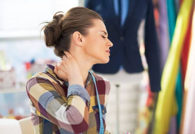 Mulher com dores no pescoço