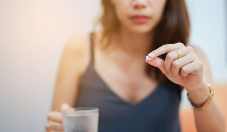 Mulher tomando um comprimido