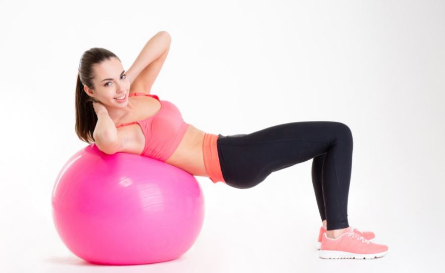 Garota fazendo abdominal na bola