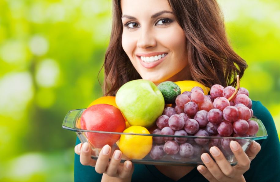 Mulher segurando travessa de frutas