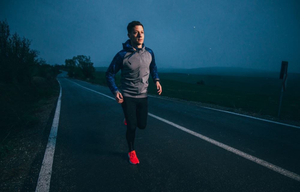 Homem correndo na rua de noite