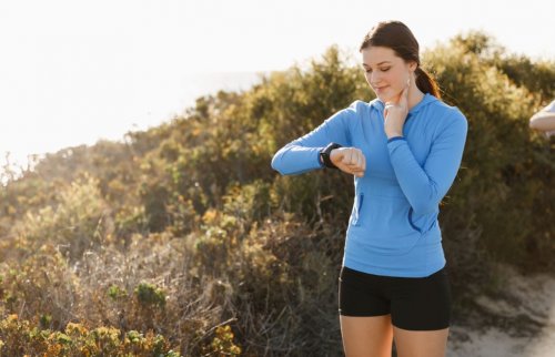 Mulher olhando no relógio enquanto sai para correr