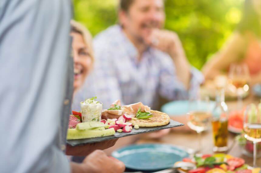 Uma tabua de queijos e legumes sendo servida