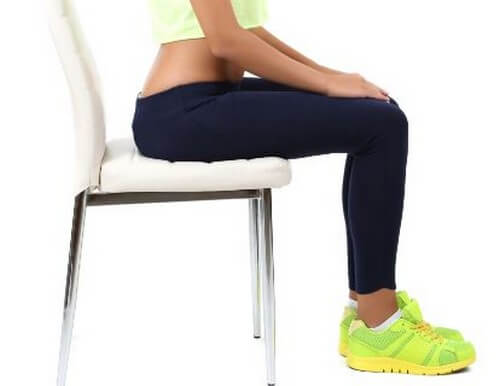 Mulher sentada em uma cadeira com roupa de academia