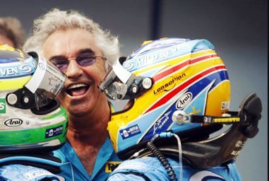 Dois pilotos de fórmula 1 comemorando junto com uma pessoa da equipe