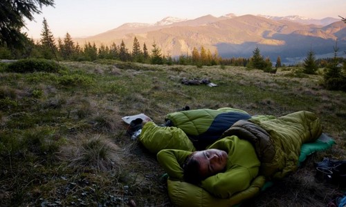 Homem dormindo em saco de dormir