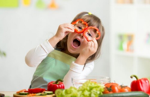 Criança brincando com pimentões cortados