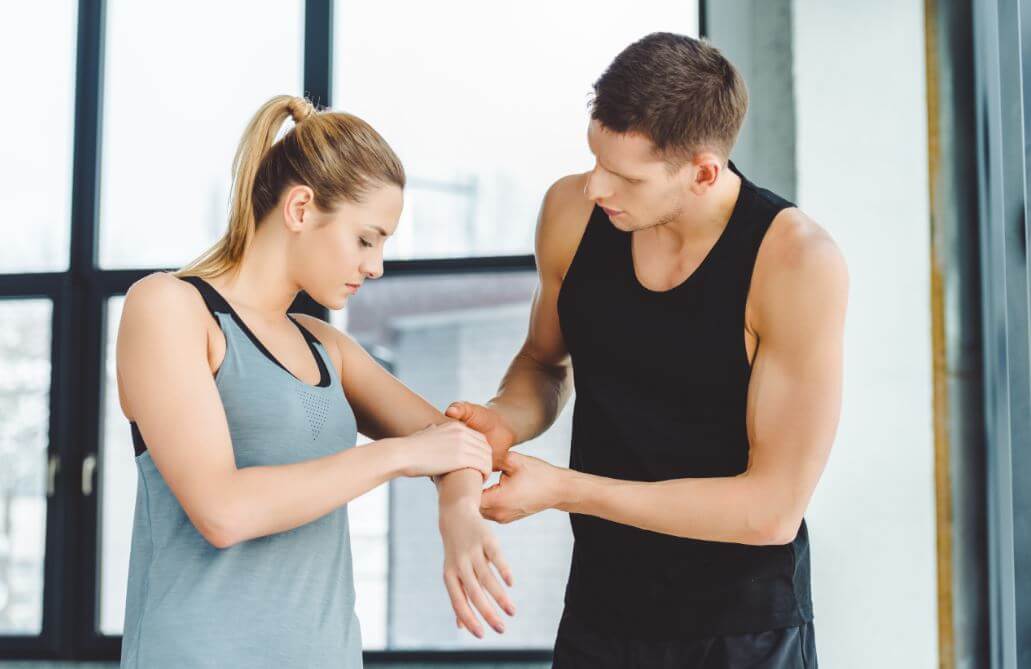 Aluna na academia com dor no cotovelo