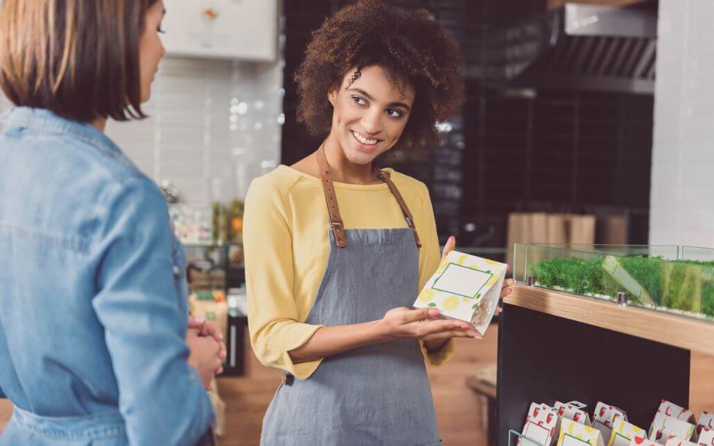 Vendedora mostrando produto para cliente