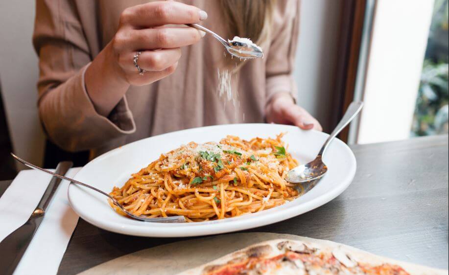 Mulher comendo carboidratos com queijo