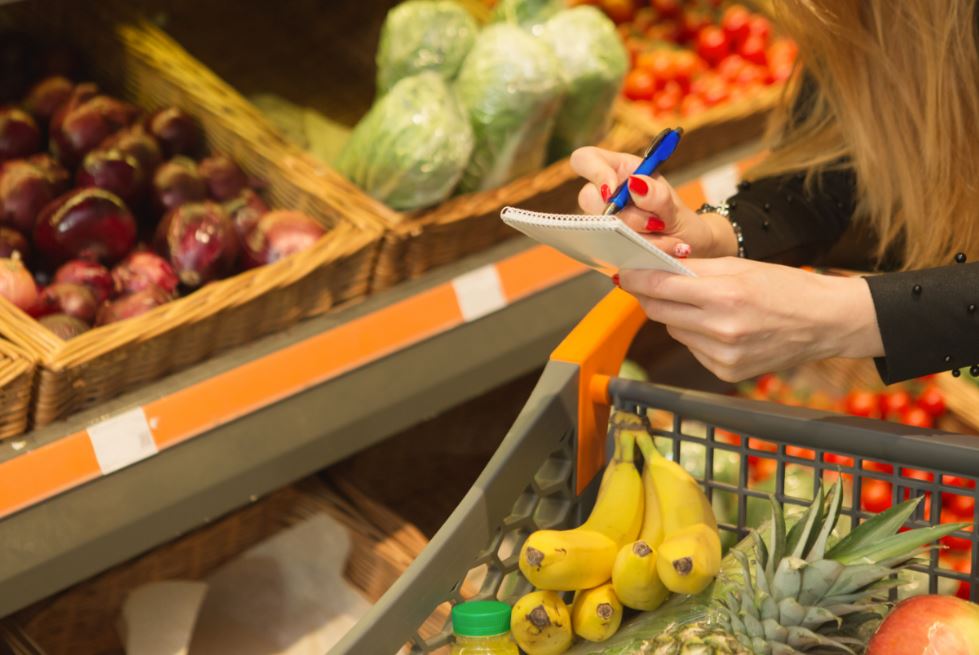 Mulher com lista de compras no mercado