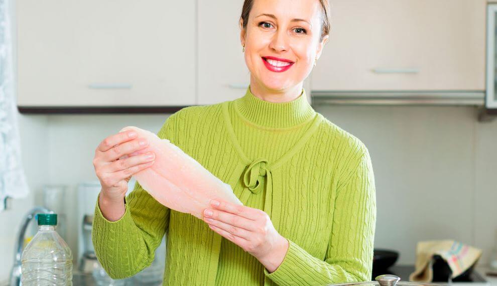 Mulher segurando filé de peixe