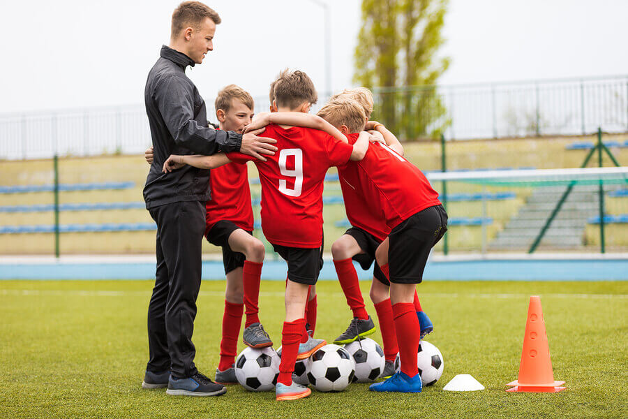 Treinador com equipe de futebol infantil