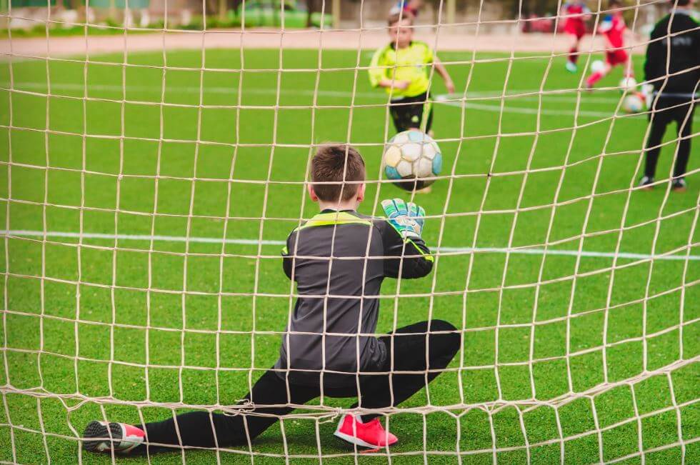 Criança cobrando penalti