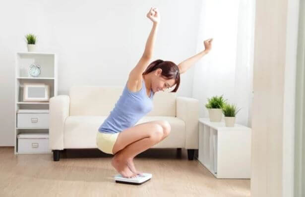 Mulher comemorando ao se pesar