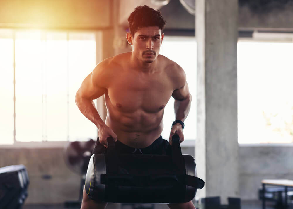 Homem fazendo remada com peso