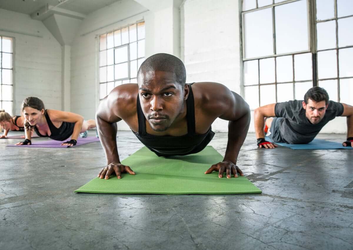Turma fazendo flexões em aula fitness